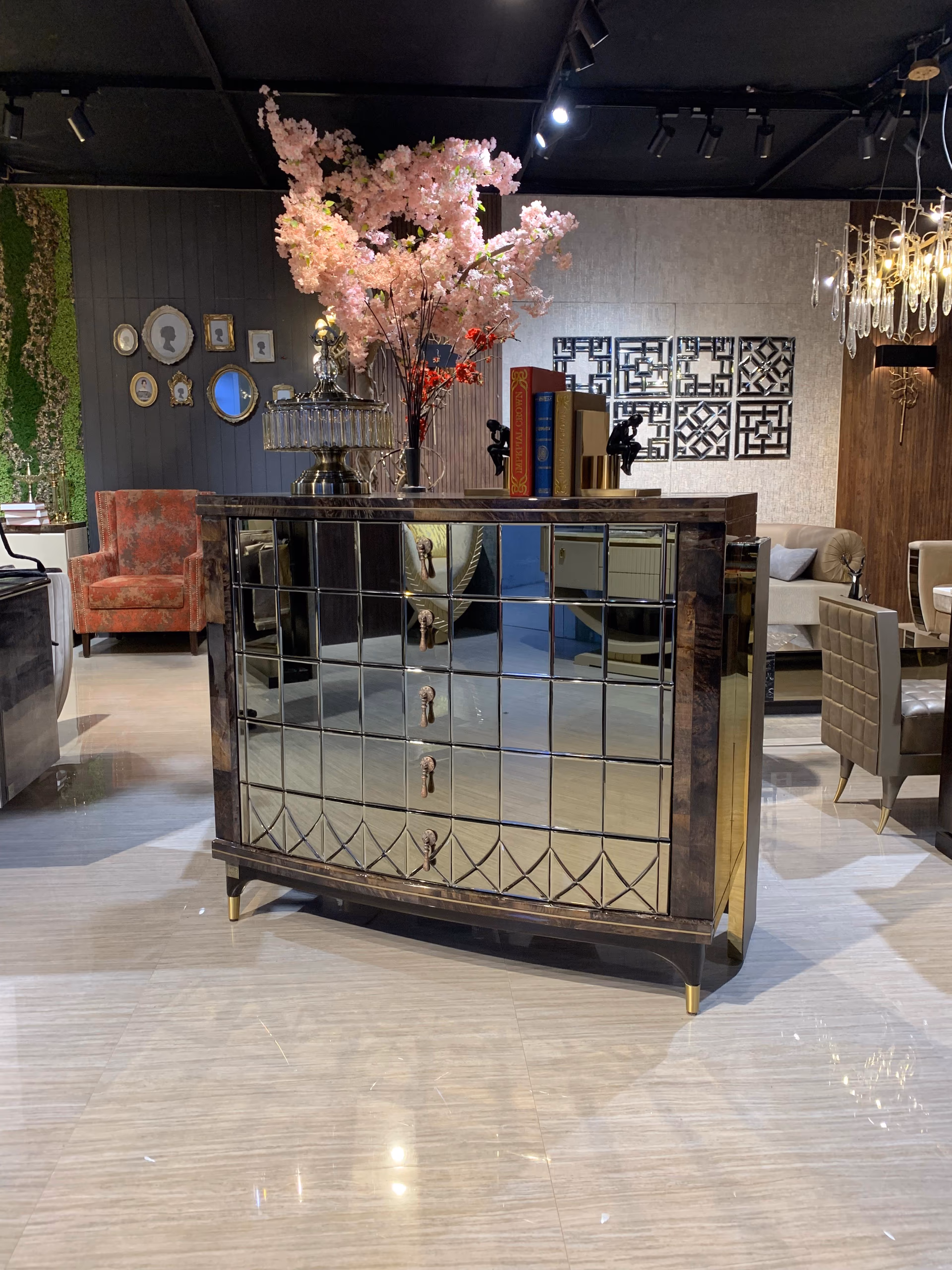 Chest of drawers faced in a grid of bevelled antiqued mirror tiles with bronze teardrop drop handles, dark burl-wood sides and brass-tipped legs.