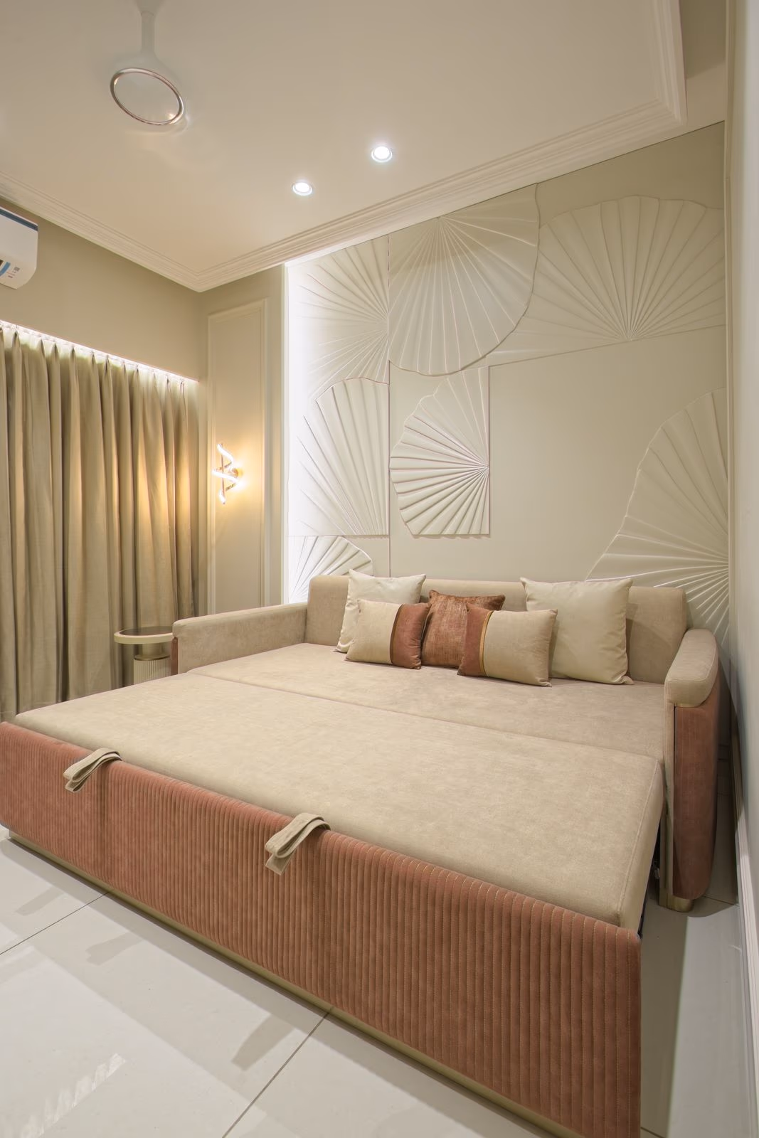 Cream and blush channel-tufted daybed pulled out into a full bed, set against a fan-textured wall panel.