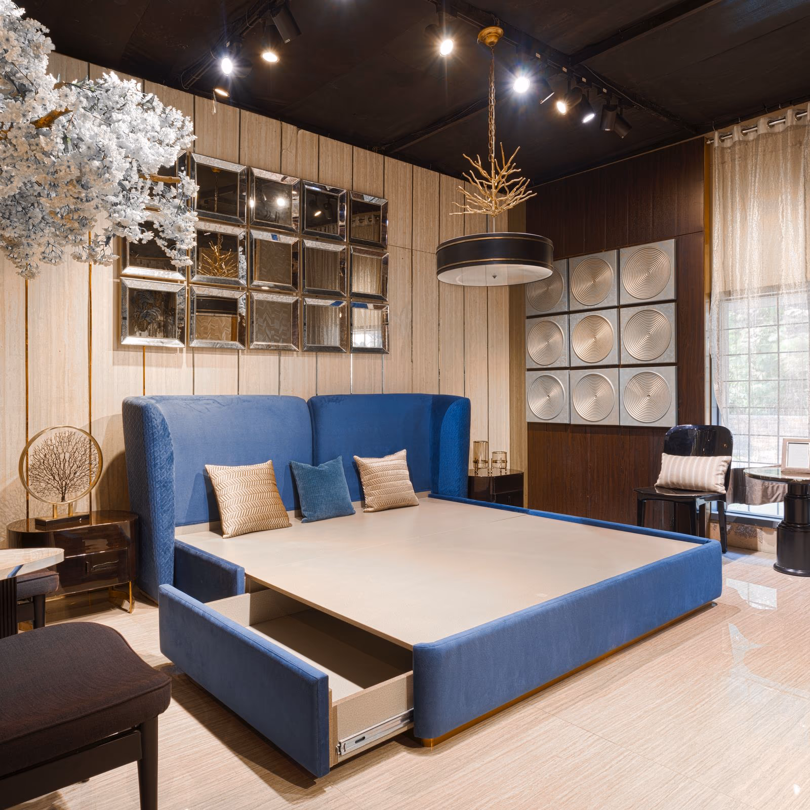 Navy blue velvet wingback bed with a quilted headboard and an open footboard storage drawer in a styled bedroom.