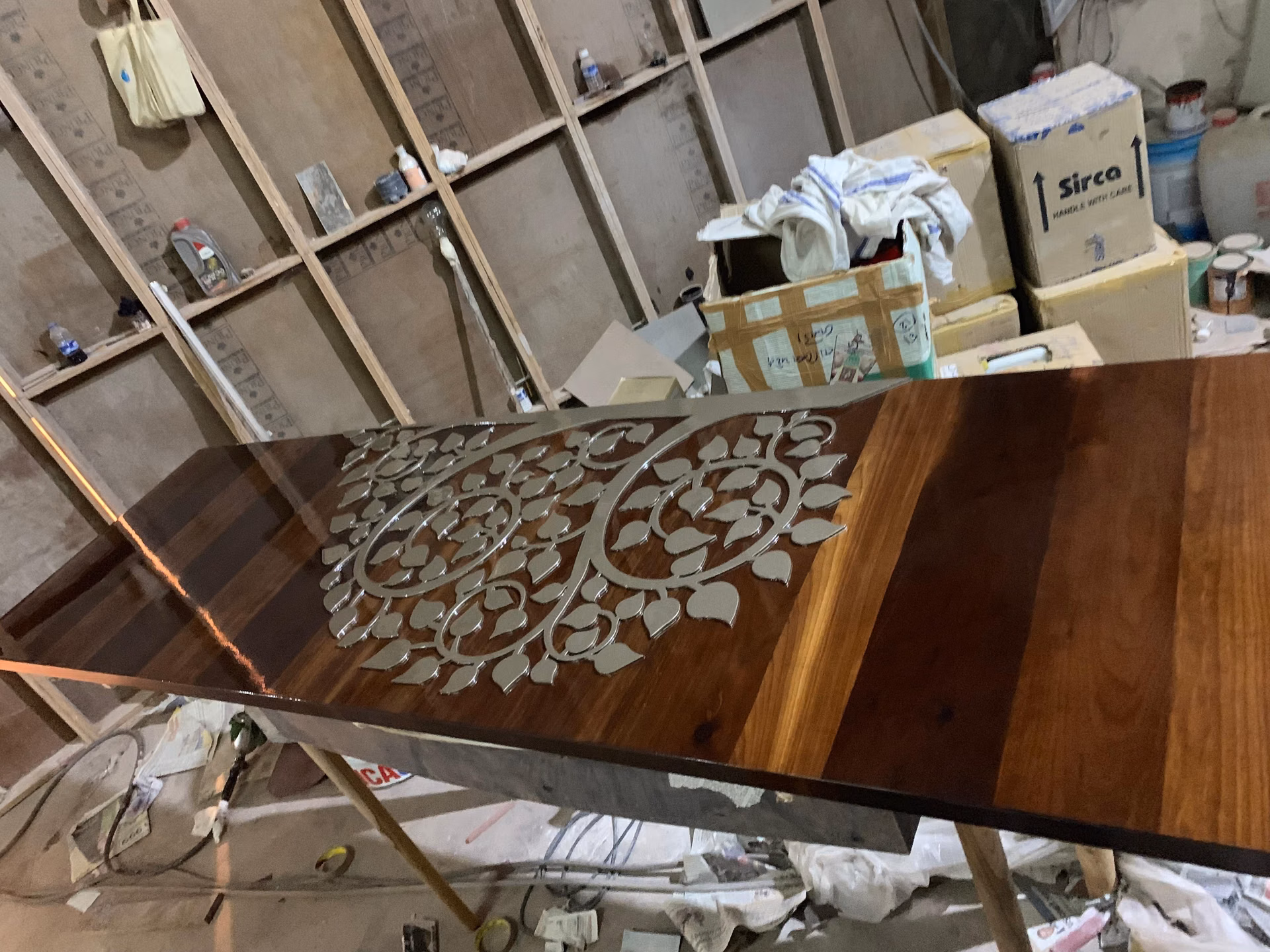 A finished Designatore silver bodhi-leaf inlay panel, every leaf cut and set into dark polished wood by hand.