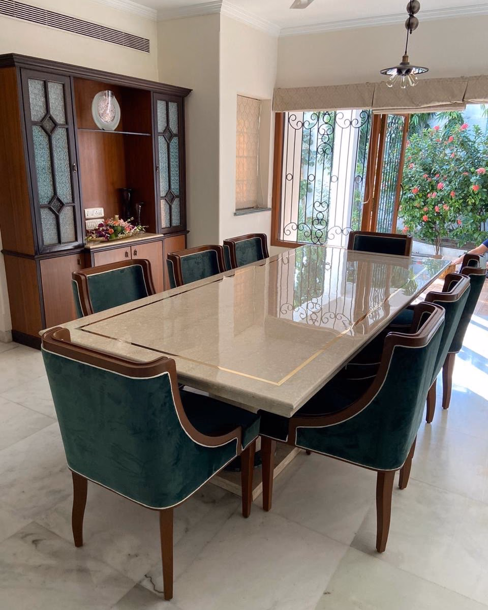 Eight-seat dining set with a cream marble top inlaid with a brass border line, and forest green velvet chairs piped in cream on solid walnut frames with sabre legs.