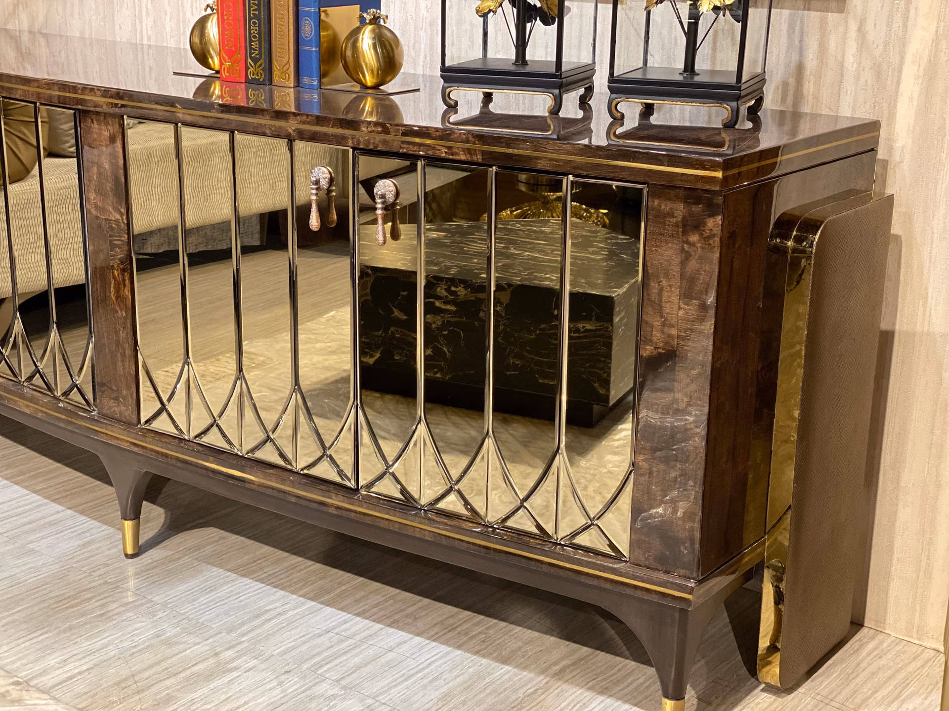 Angled close view of the sideboard showing the diamond-cut mirror bevels, brass trim and a silver drop handle catching the light.