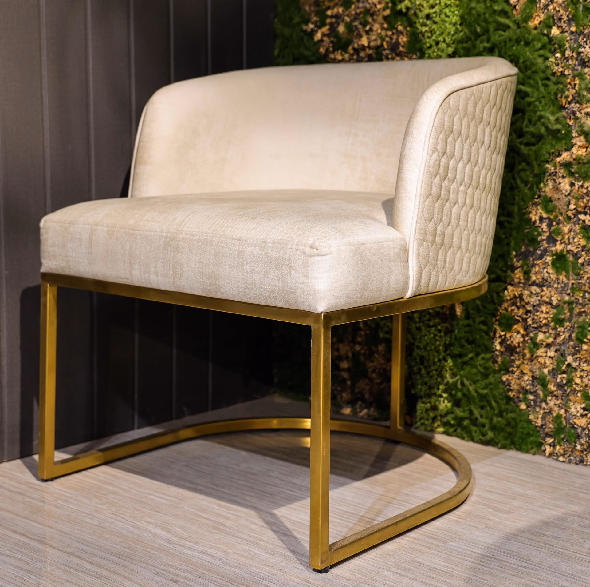 Cream velvet barrel dining chair with honeycomb-quilted back panel and a brass ring base.