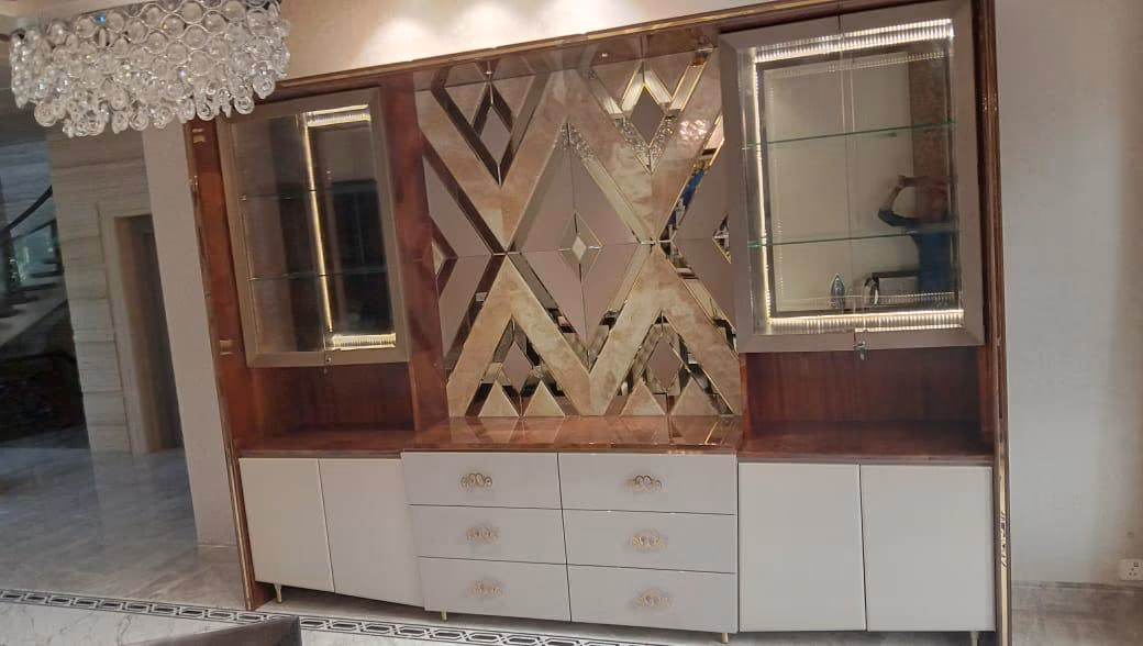 Large wall display unit with two lit glass cabinets flanking a bronze-mirror diamond-pattern back panel, over a marble-topped base of drawers and doors.