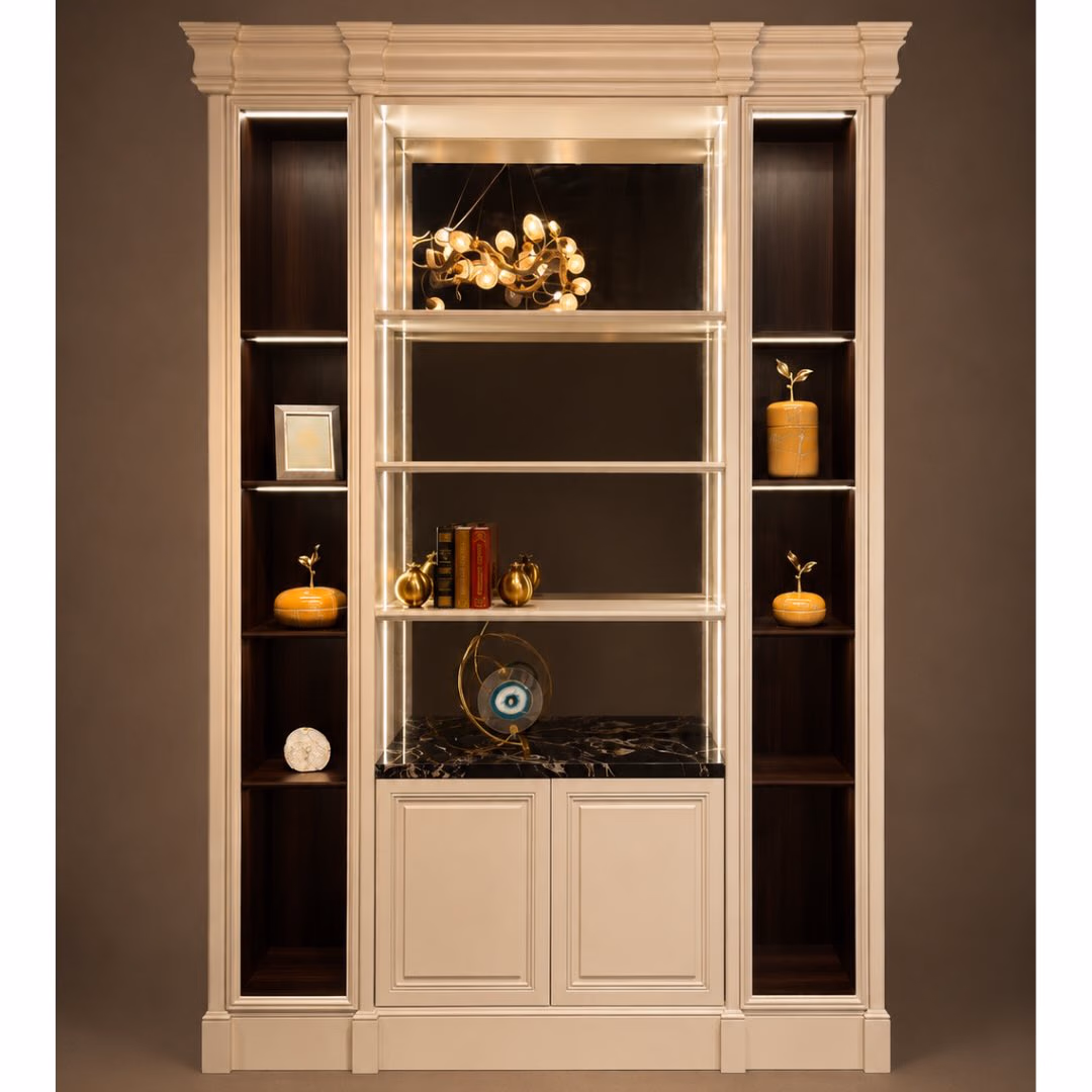 Ivory painted classical display bookcase with a moulded cornice, two tall side bays in dark veneer, a wide backlit centre section with glass shelves and a two-door cupboard below.