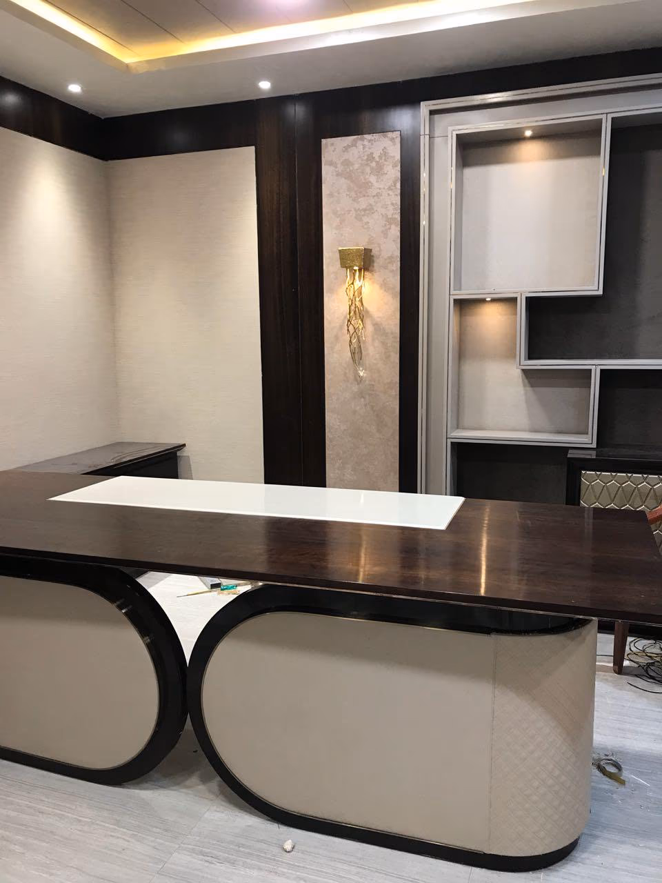 Side angle of the same executive desk showing the depth of the oval leather bases and the white inset running across the walnut top.