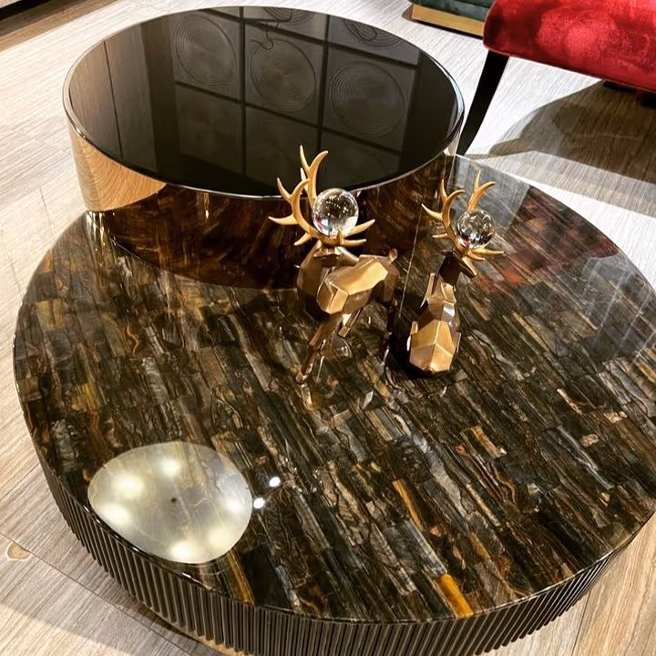 A round made-to-space cocktail table with a stone top and a fluted brass base.