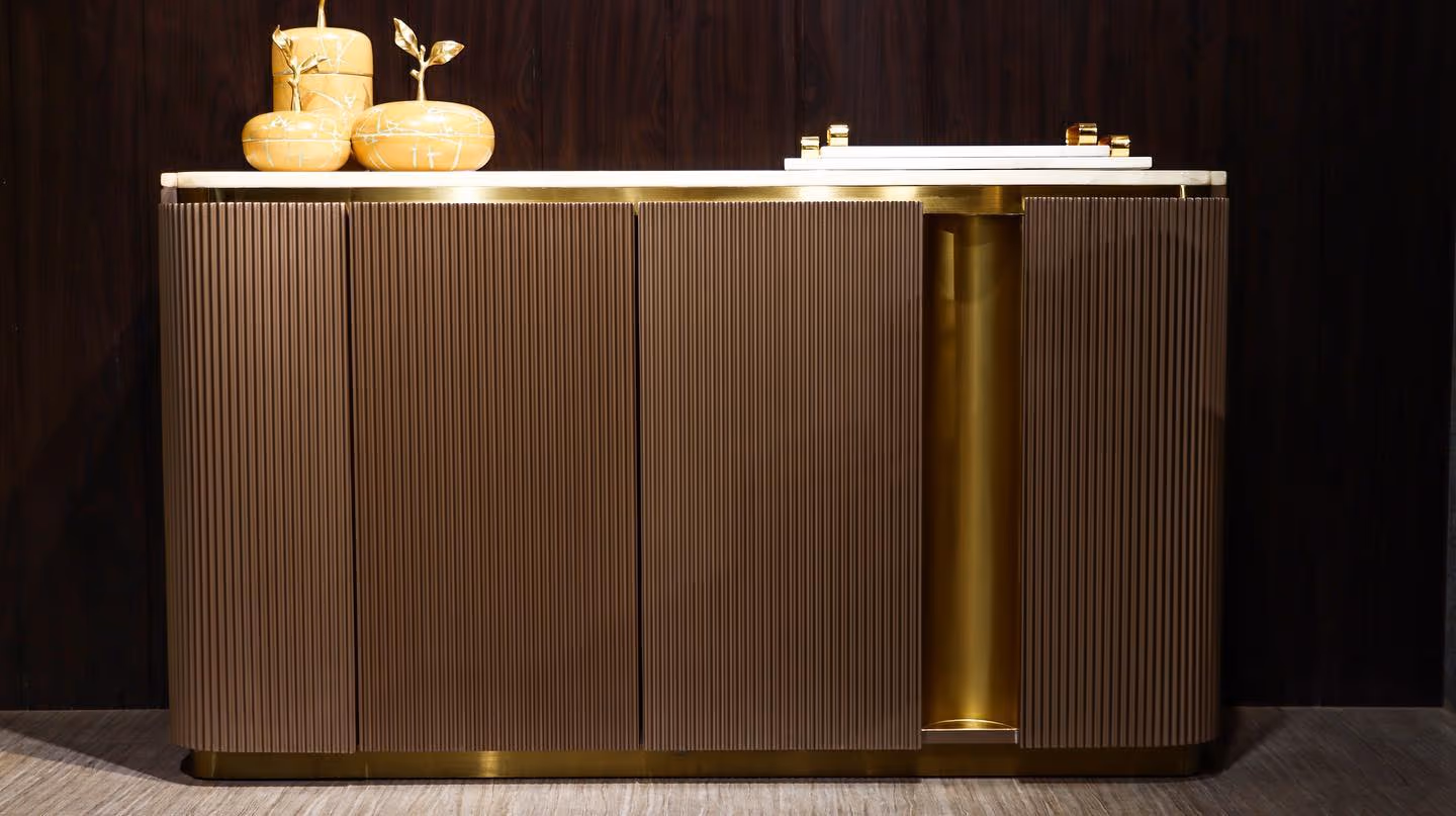 A fluted bronze sideboard with a marble top, showing hand craftsmanship.