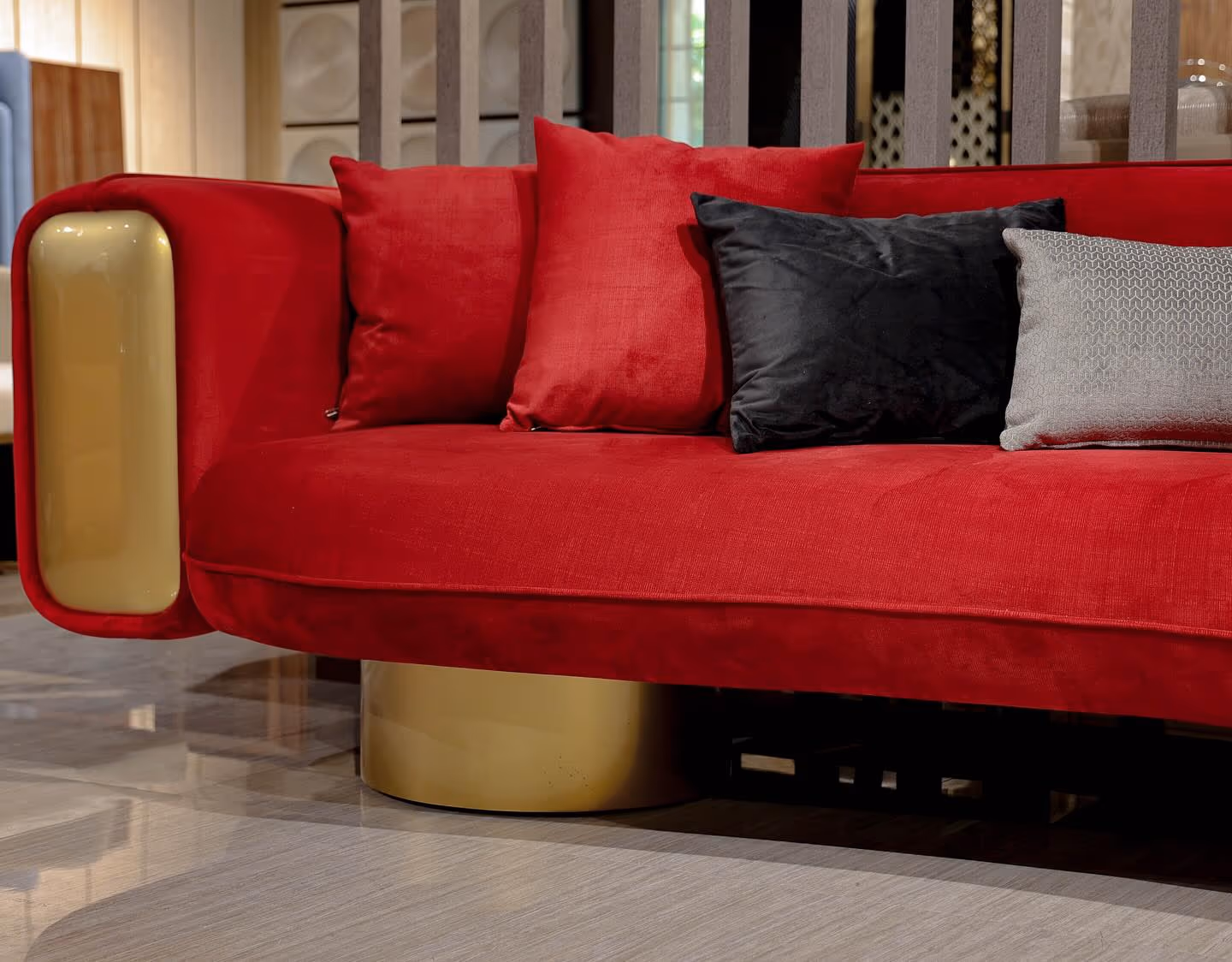 A scarlet velvet curved sofa with a gold-lacquer arm on a brass base.