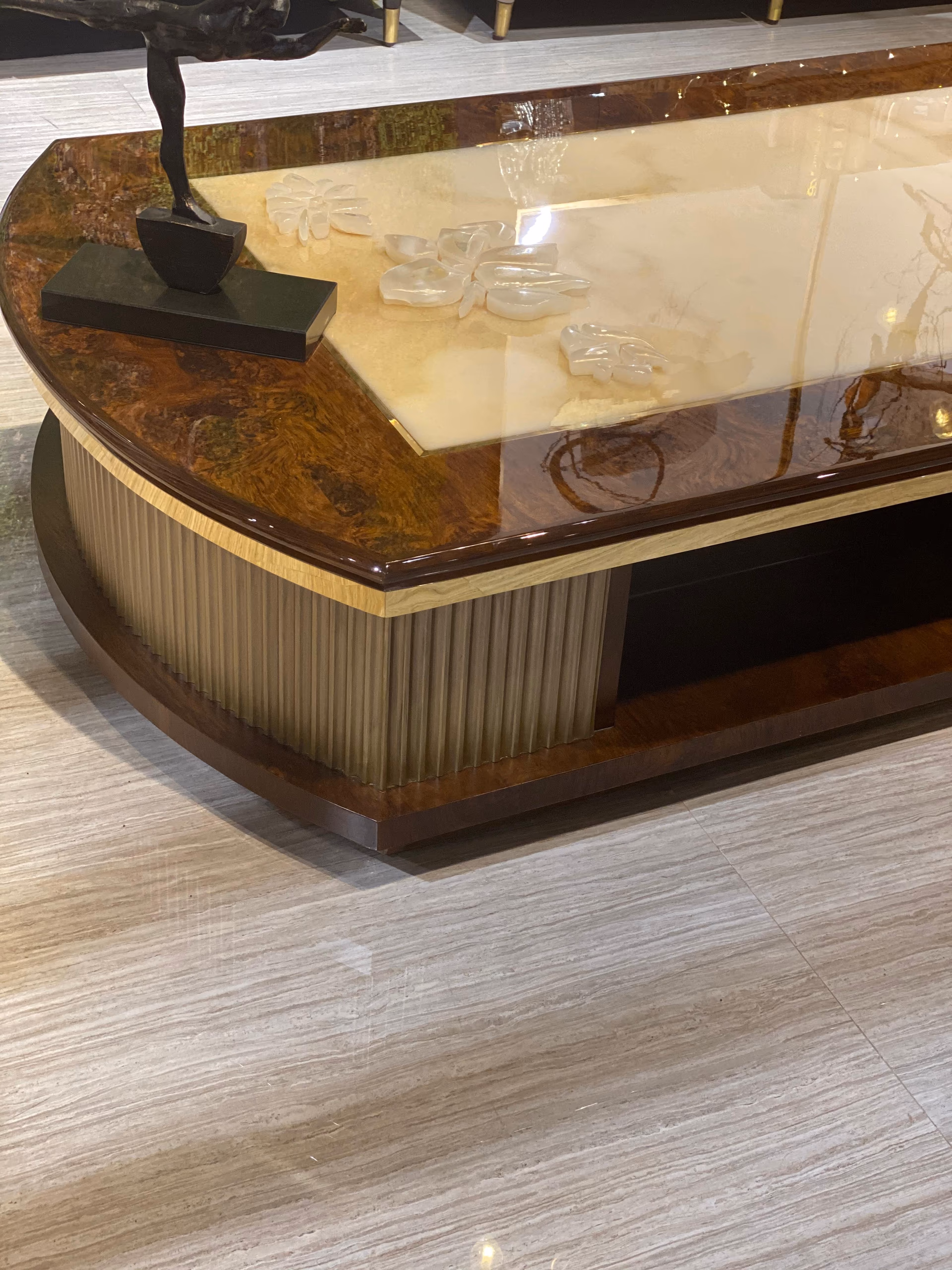 Close view of the carved flower pattern in the cream onyx inset, framed by the polished walnut-burl edge.