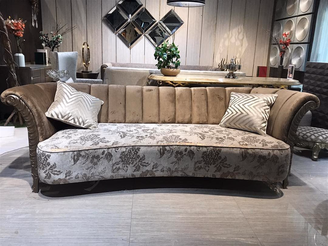Curved four-seat sofa with a channel-tufted champagne velvet back, rolled scroll arms studded with nailheads, a damask-woven seat and a hand-carved silvered show-wood frame.