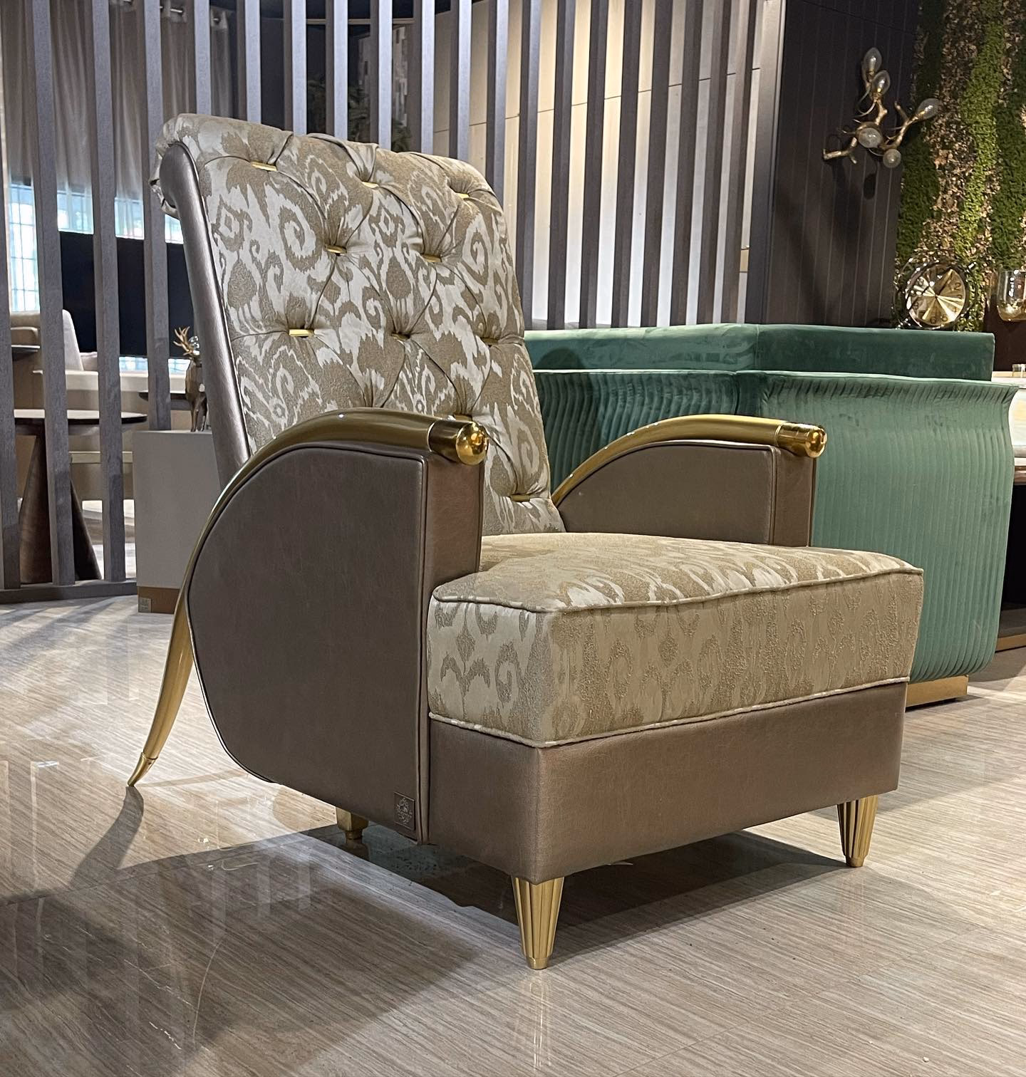 Lounge chair with a tall button-tufted ikat-pattern back and seat, taupe leather outer arms and sides, polished gold arm caps and fluted gold tapered legs.