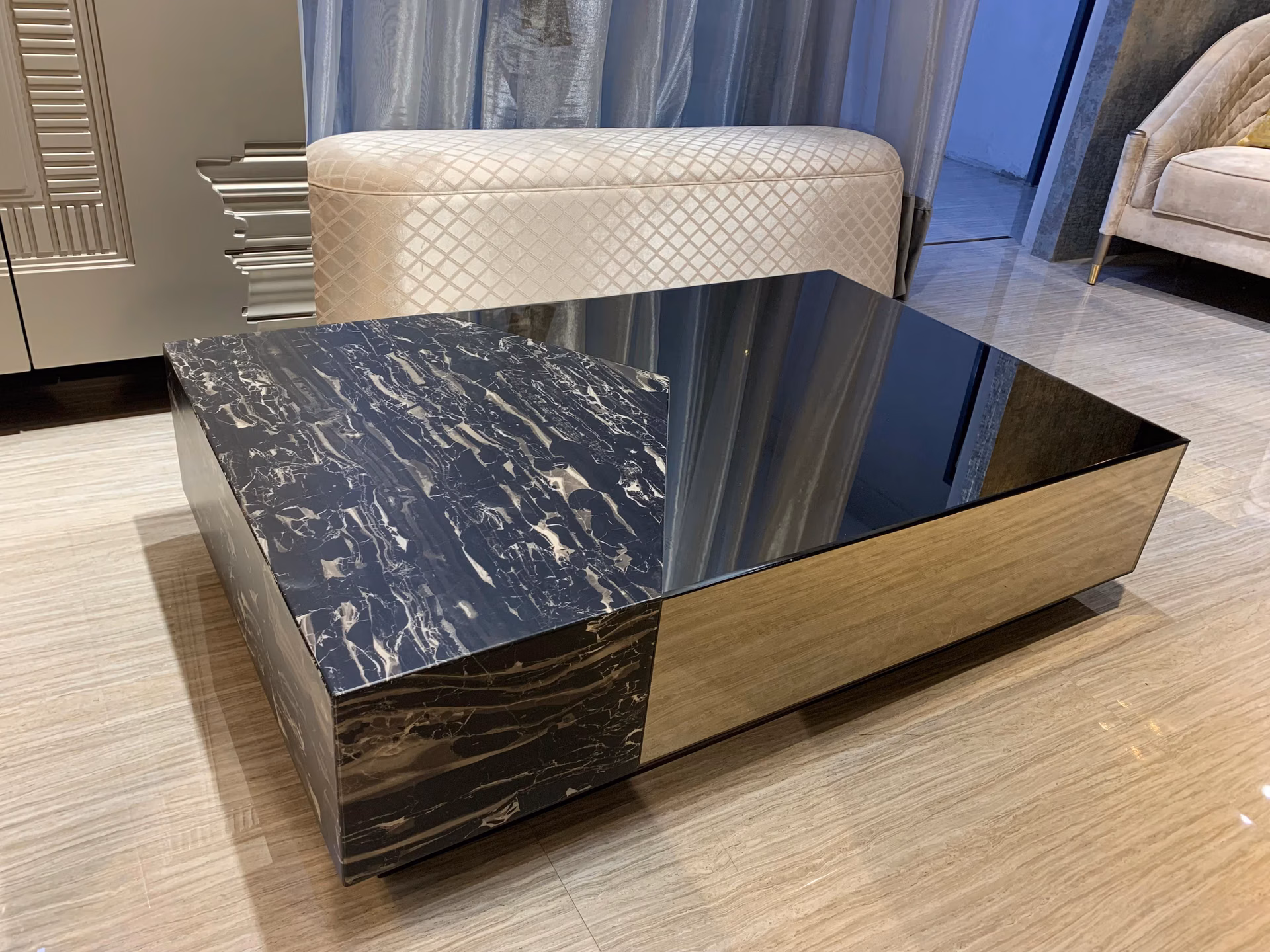 Low rectangular coffee table whose top is split on the diagonal, half black-and-white marble and half bronze mirror glass, with a bronze mirrored body.