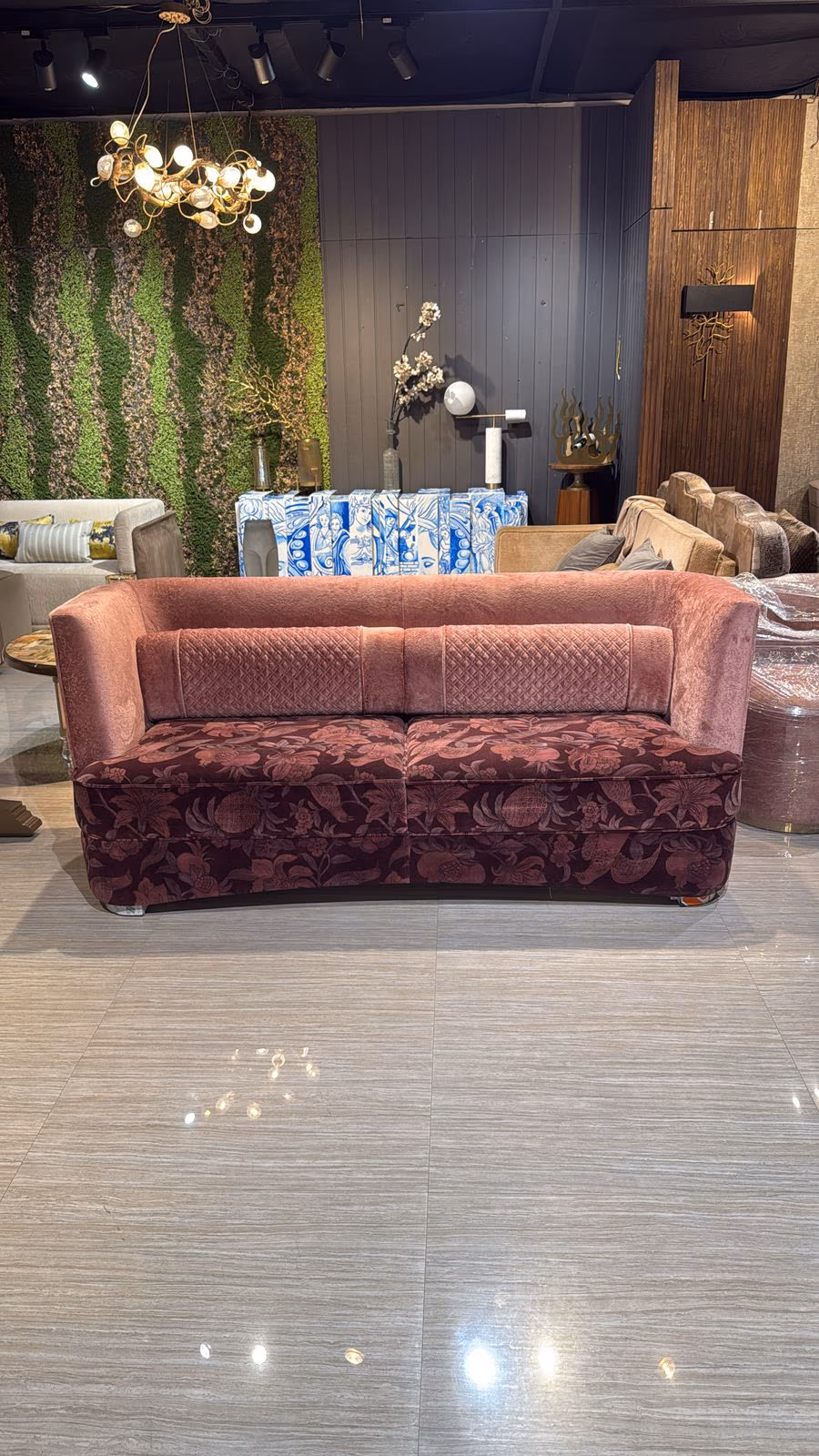 Curved mauve velvet sofa with a diamond-quilted backrest cushion over a burgundy floral-print base and skirt.