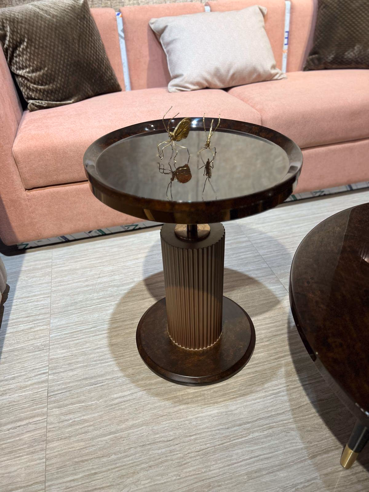 Round side table with a mirrored glass top framed in burl wood, resting on a fluted brass column and burl wood base.