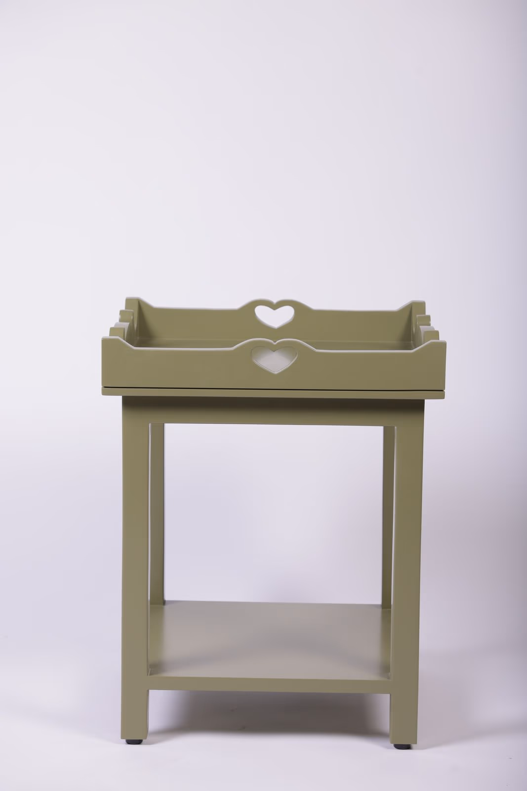 Sage green painted wood side table with a heart-shaped cut-out handle and an open lower shelf.