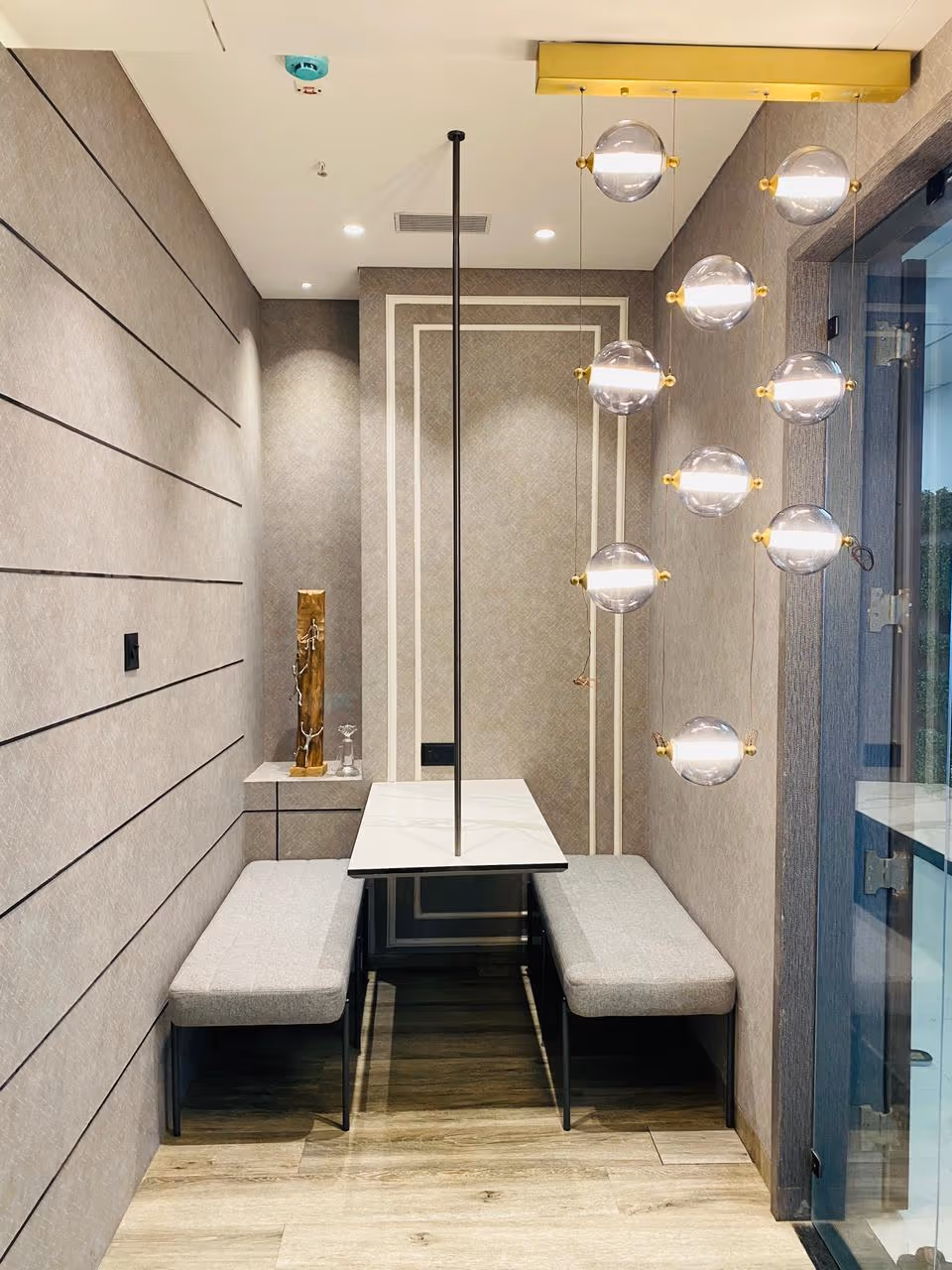 Office breakout booth with bench seats and glass globe pendant lights.