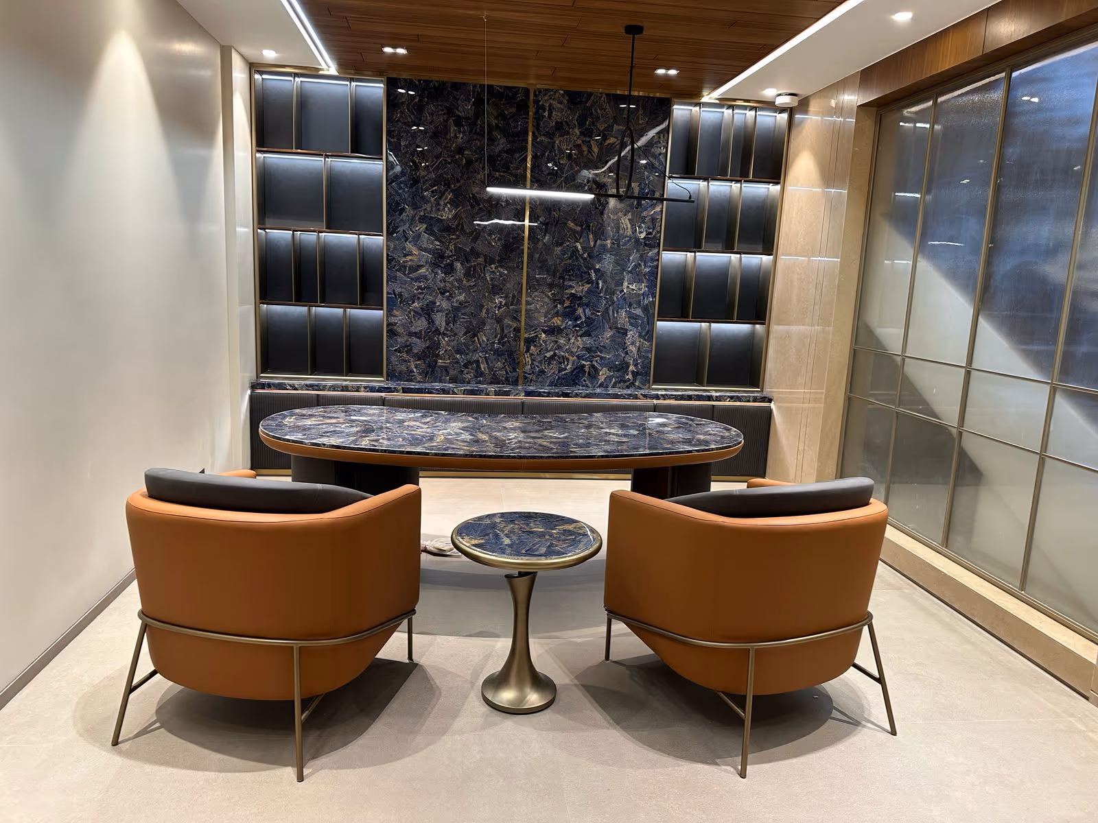 Luxury chairman office with a blue sodalite stone wall and oval stone desk.