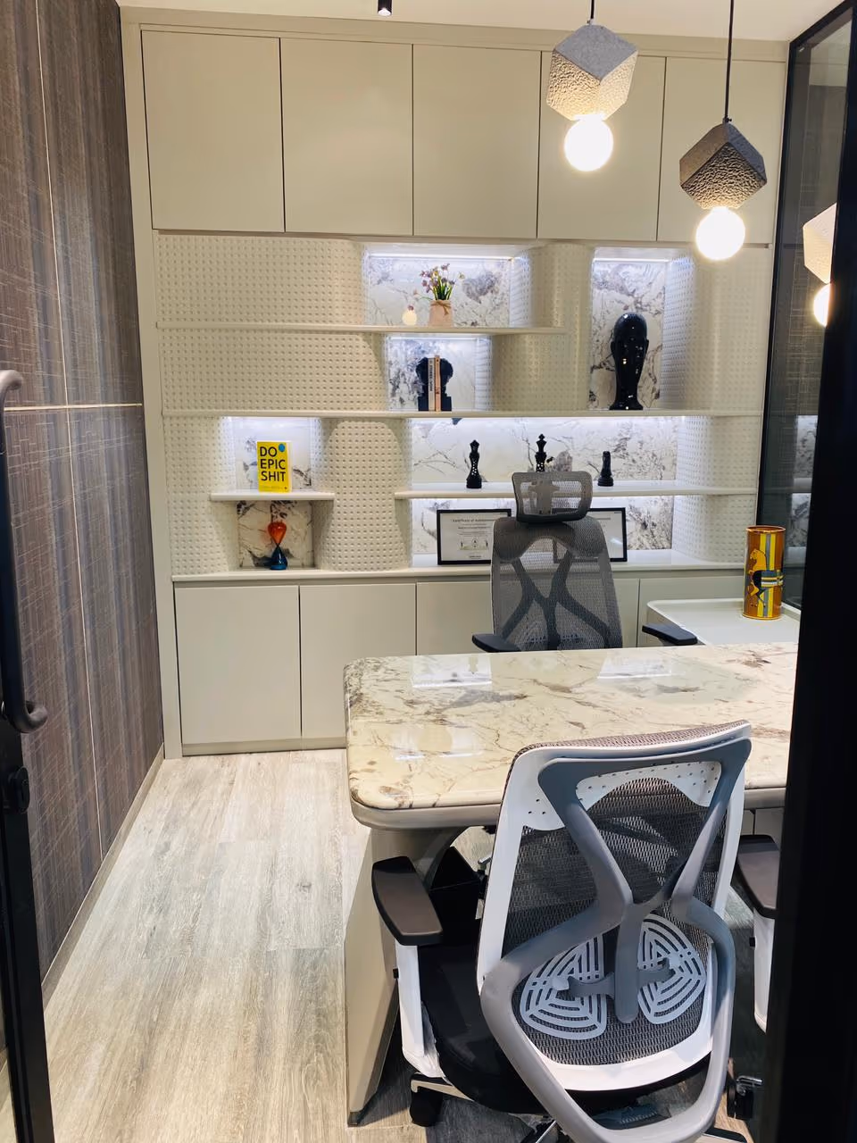 Executive cabin with a backlit marble display cabinet and marble desk.