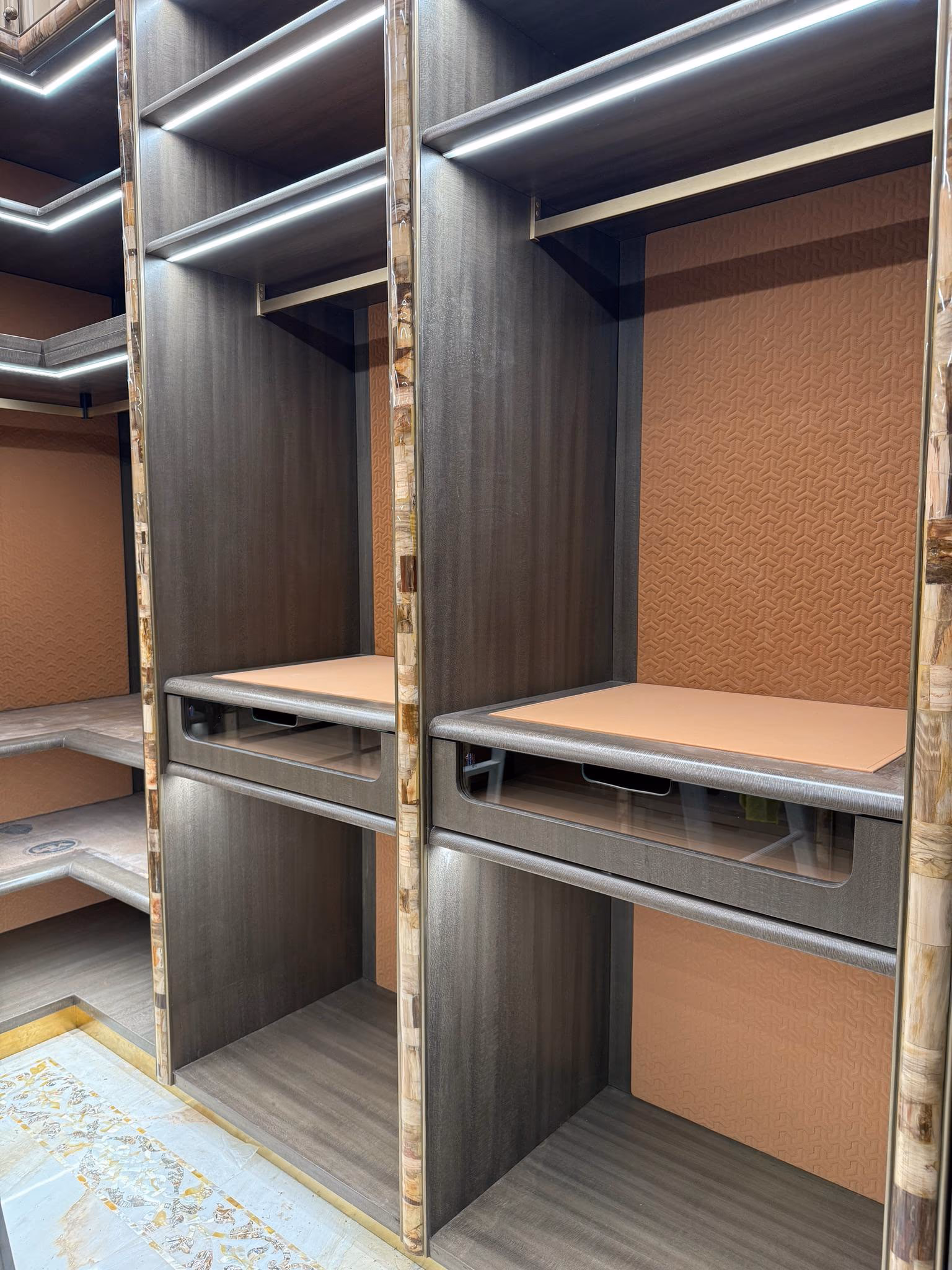 A drawer bank inside a made-to-measure walk-in wardrobe, with shallow jewellery trays above deeper drawers for folded clothes.
