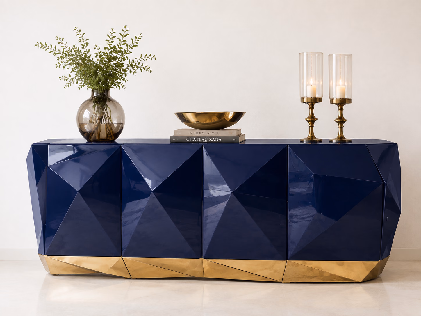 Designatore console table shown alone, built as a high-gloss navy lacquered body with a stepped geometric front profile, sitting on a slim brushed gold metal base.